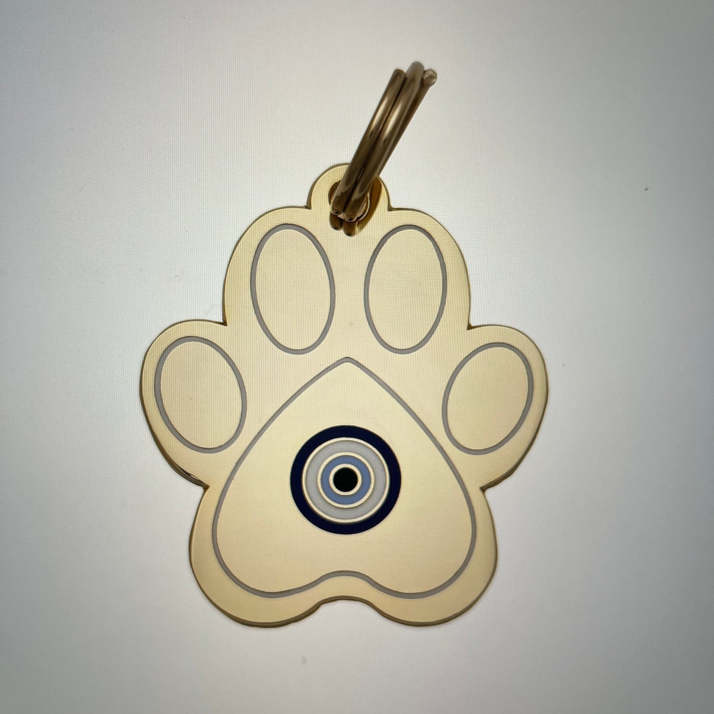 Paw-shaped keychain with a central circular design on a white background